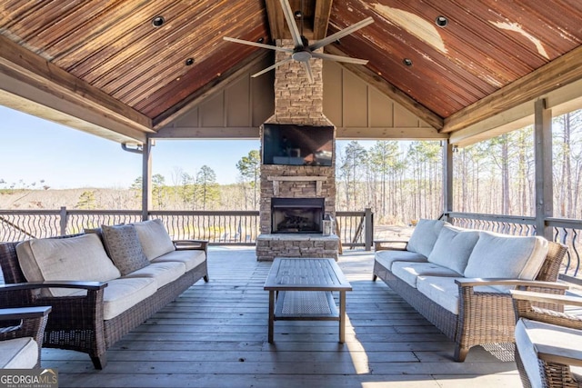 deck featuring ceiling fan and an outdoor living space with a fireplace