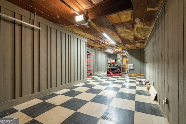 basement with cooling unit, wood ceiling, and wood walls