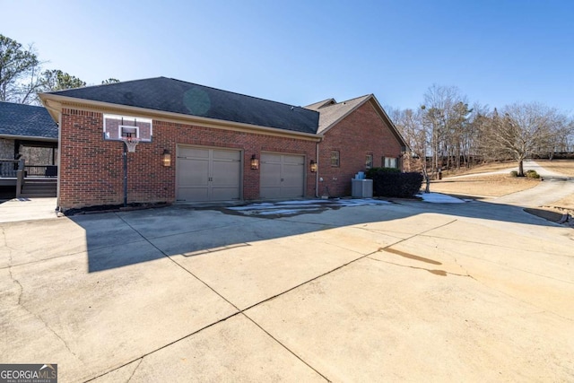 view of side of property with central air condition unit and a garage