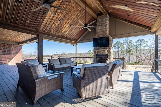 deck featuring ceiling fan and an outdoor living space with a fireplace