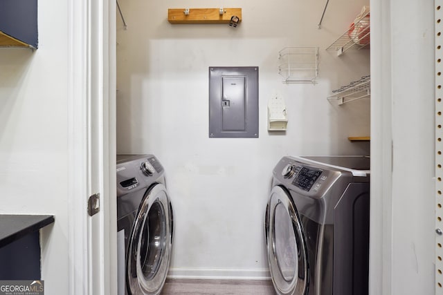 washroom featuring washer and dryer, hardwood / wood-style flooring, and electric panel