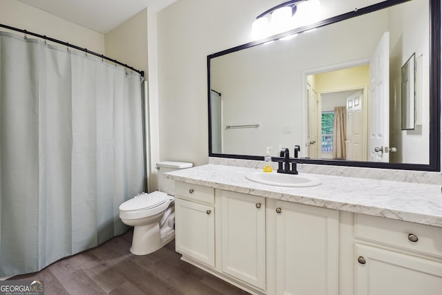 bathroom featuring wood-type flooring, toilet, and vanity