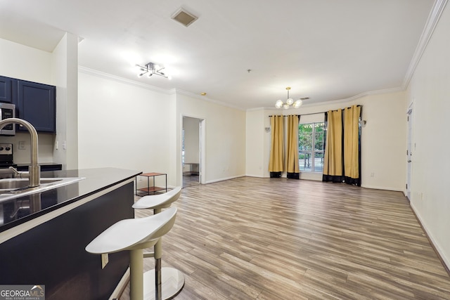 kitchen featuring crown molding, blue cabinets, light hardwood / wood-style floors, and a notable chandelier