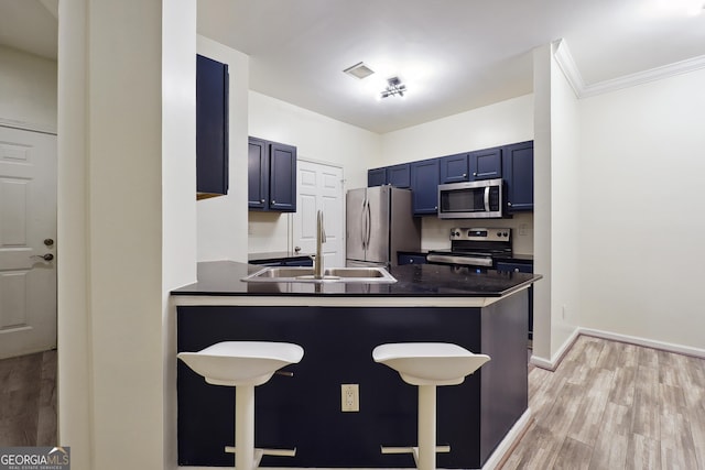 kitchen with a breakfast bar, kitchen peninsula, sink, stainless steel appliances, and ornamental molding