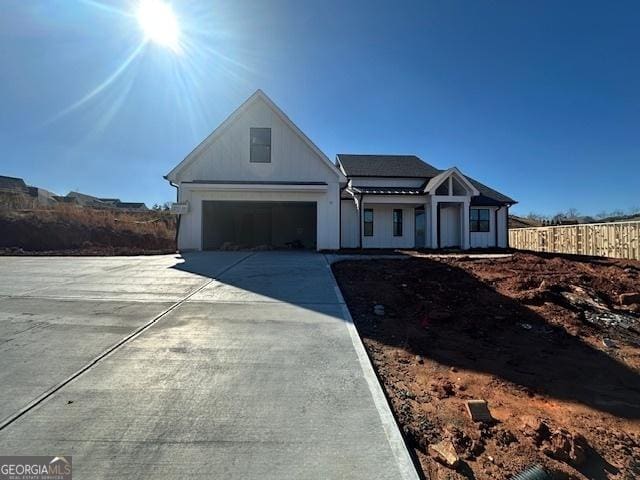 view of front of home featuring a garage, driveway, and fence