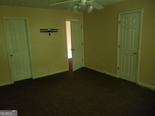 2590 Wellington Walk Pl, Lithonia, GA 30058 - unfurnished bedroom with dark colored carpet, baseboards, and ceiling fan