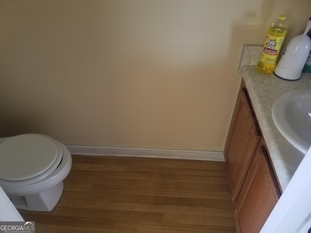 bathroom featuring toilet, vanity, and hardwood / wood-style flooring