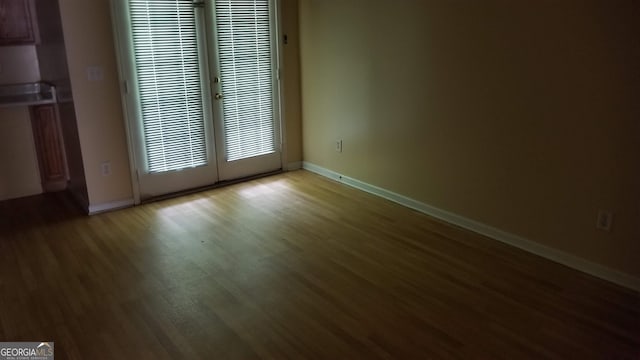 2590 Wellington Walk Pl, Lithonia, GA 30058 - unfurnished room featuring a heating unit, wood finished floors, baseboards, and french doors