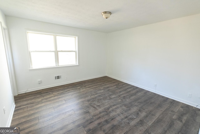 empty room featuring dark wood-type flooring