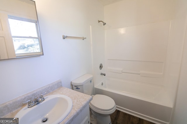 full bathroom featuring toilet, vanity, hardwood / wood-style flooring, and washtub / shower combination