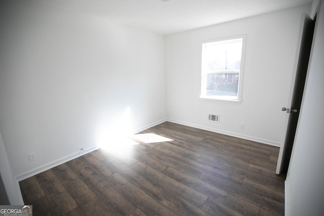 spare room featuring dark wood-type flooring