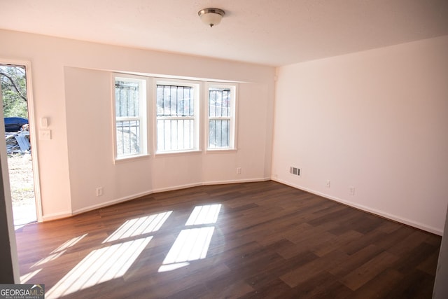 unfurnished room with dark hardwood / wood-style flooring