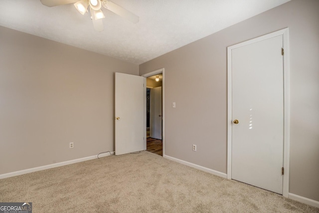 unfurnished bedroom featuring ceiling fan and light carpet