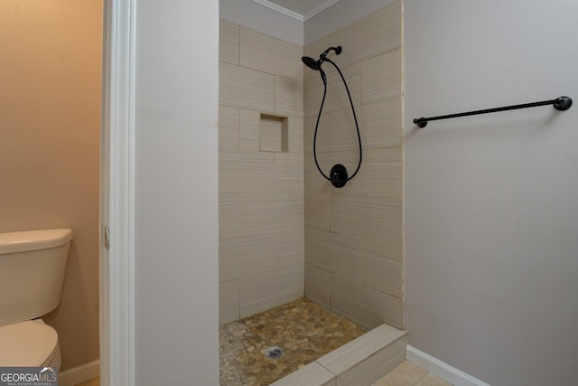 bathroom featuring toilet and a tile shower