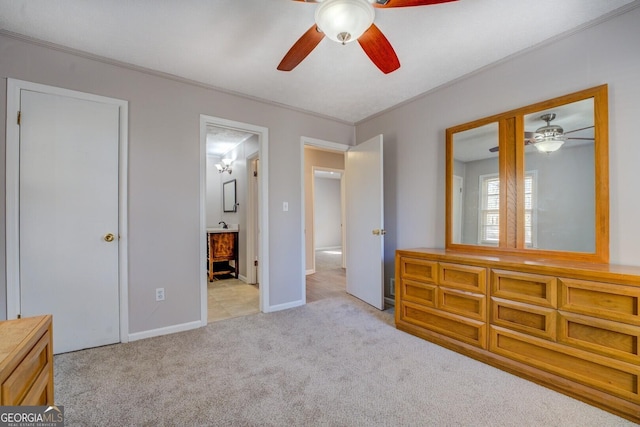 unfurnished bedroom with ceiling fan, light colored carpet, ensuite bathroom, and ornamental molding