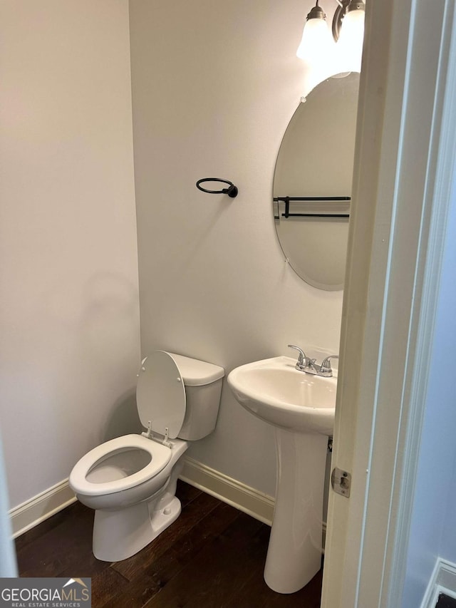 bathroom with toilet, hardwood / wood-style floors, and sink