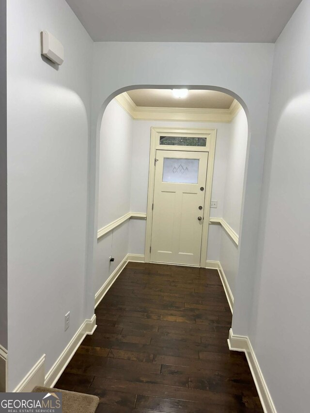 doorway with dark hardwood / wood-style floors and crown molding