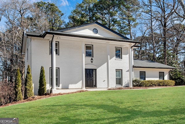 greek revival inspired property featuring covered porch and a front lawn