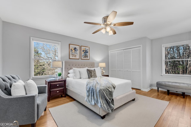 bedroom with ceiling fan, a closet, and light hardwood / wood-style flooring