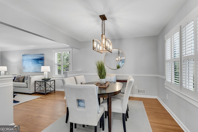 dining room featuring a notable chandelier and light hardwood / wood-style flooring