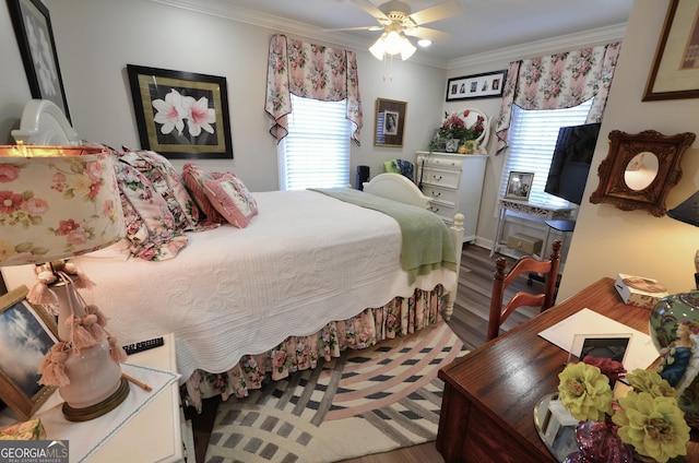 bedroom featuring ceiling fan, crown molding, wood-type flooring, and multiple windows