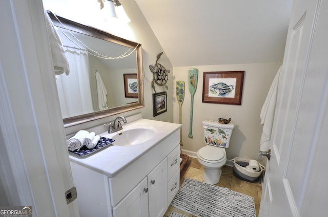 bathroom with vaulted ceiling, toilet, tile patterned floors, and vanity