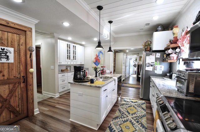 kitchen featuring appliances with stainless steel finishes, a center island, light stone countertops, white cabinets, and sink