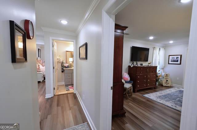 hallway with hardwood / wood-style flooring and crown molding