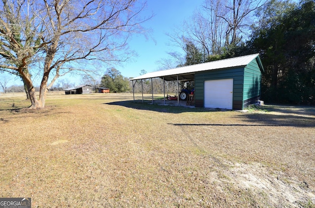 view of yard with a garage, an outdoor structure, and a carport