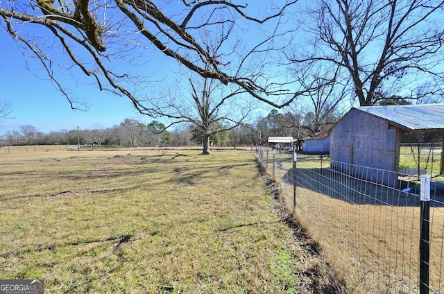 view of yard with a rural view and an outdoor structure