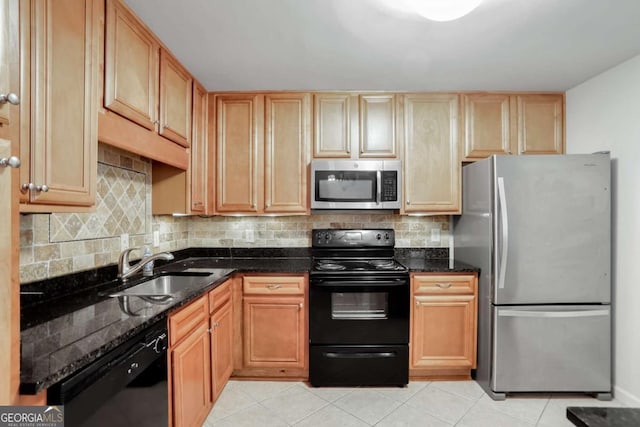 kitchen with black appliances, sink, dark stone countertops, and decorative backsplash