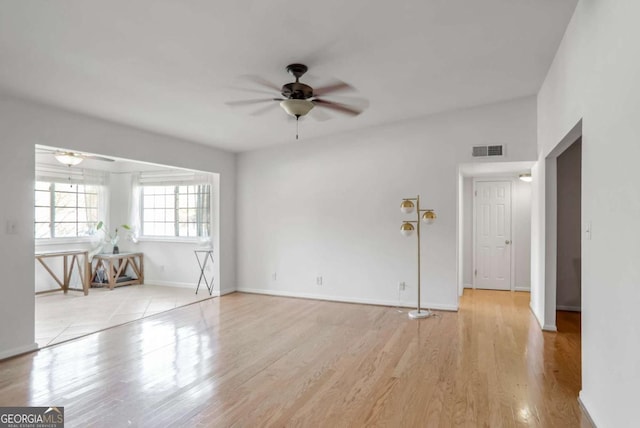 empty room with ceiling fan and light hardwood / wood-style flooring