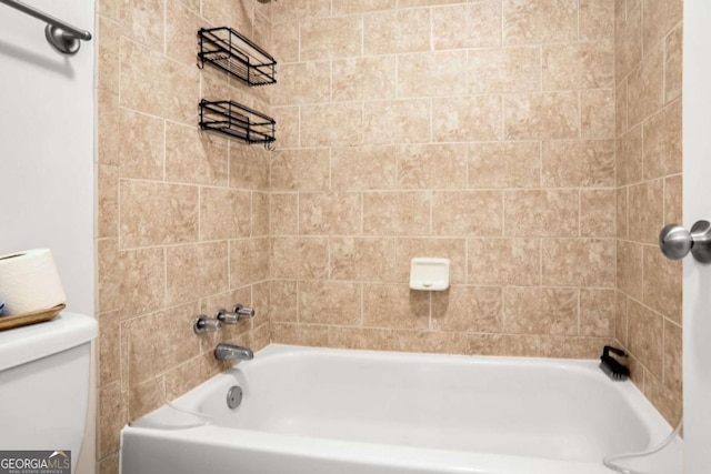 bathroom featuring toilet and tiled shower / bath combo