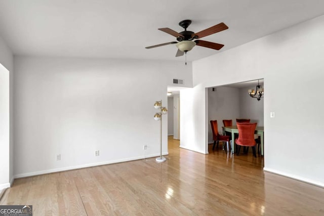 unfurnished living room featuring light wood-type flooring and ceiling fan with notable chandelier