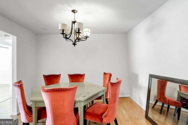 dining space featuring light wood-type flooring and a chandelier