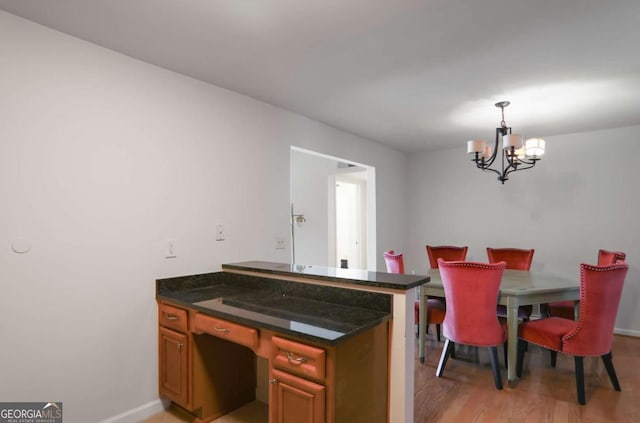 dining space featuring light wood-type flooring and a chandelier