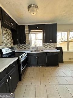 kitchen featuring range with two ovens, black dishwasher, sink, and a wealth of natural light