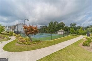 view of home's community with a yard and tennis court