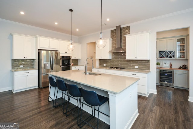 kitchen featuring white cabinetry, wine cooler, wall chimney range hood, and appliances with stainless steel finishes