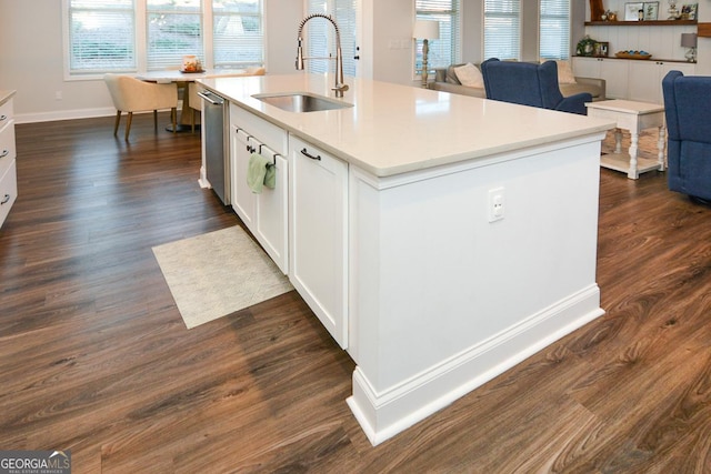 kitchen featuring white cabinetry, stainless steel dishwasher, sink, dark wood-type flooring, and an island with sink