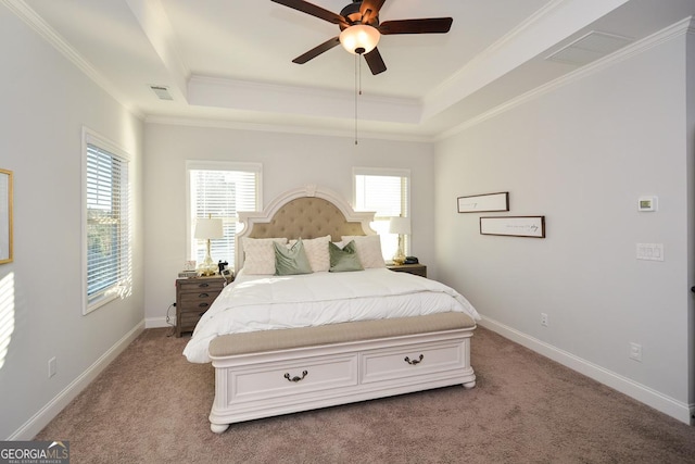 carpeted bedroom with ceiling fan, a tray ceiling, and crown molding