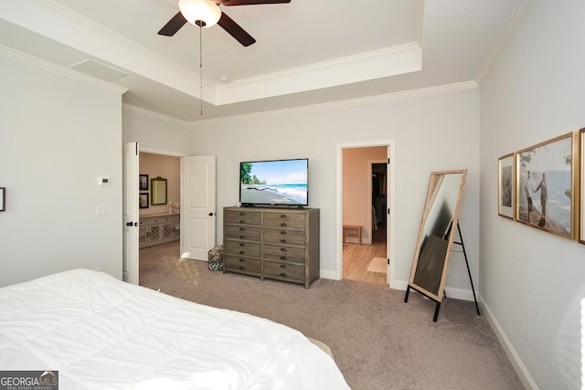 carpeted bedroom featuring ceiling fan, crown molding, and a tray ceiling