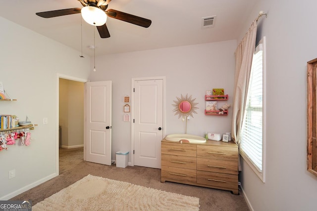 bedroom featuring light carpet, multiple windows, and ceiling fan