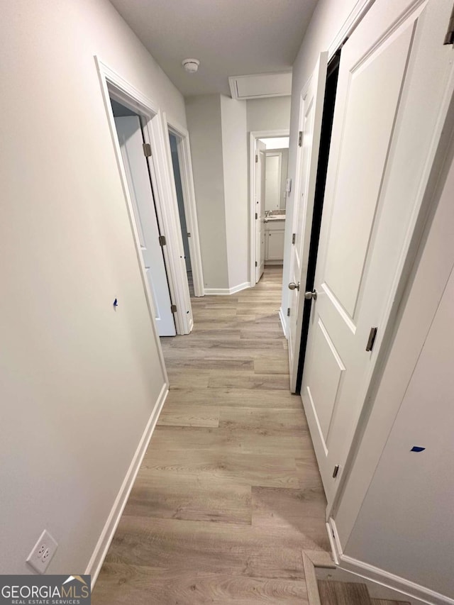 hallway with light hardwood / wood-style floors