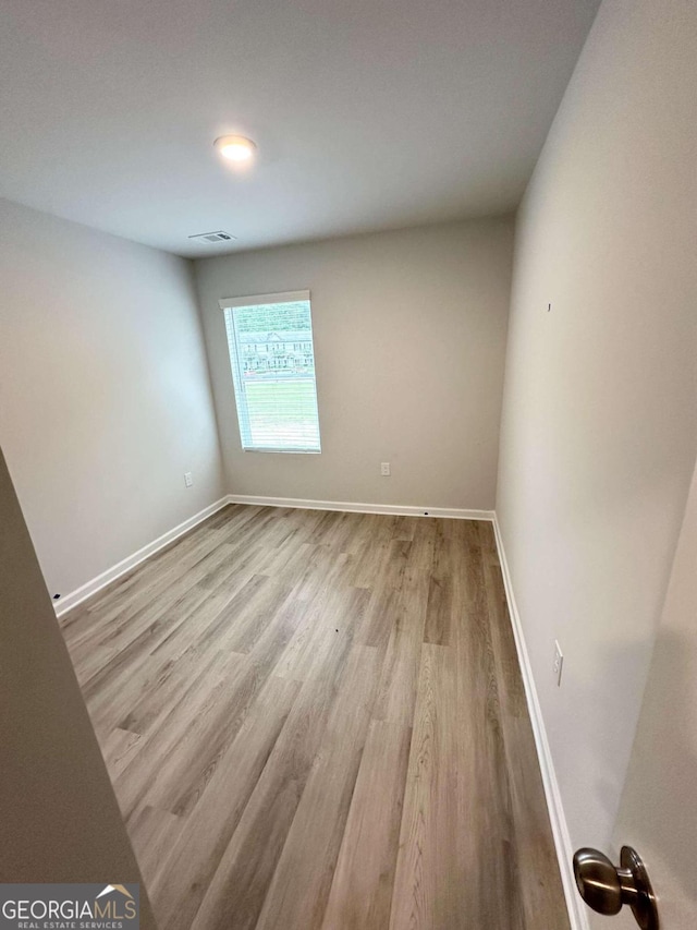 unfurnished room with light wood-type flooring