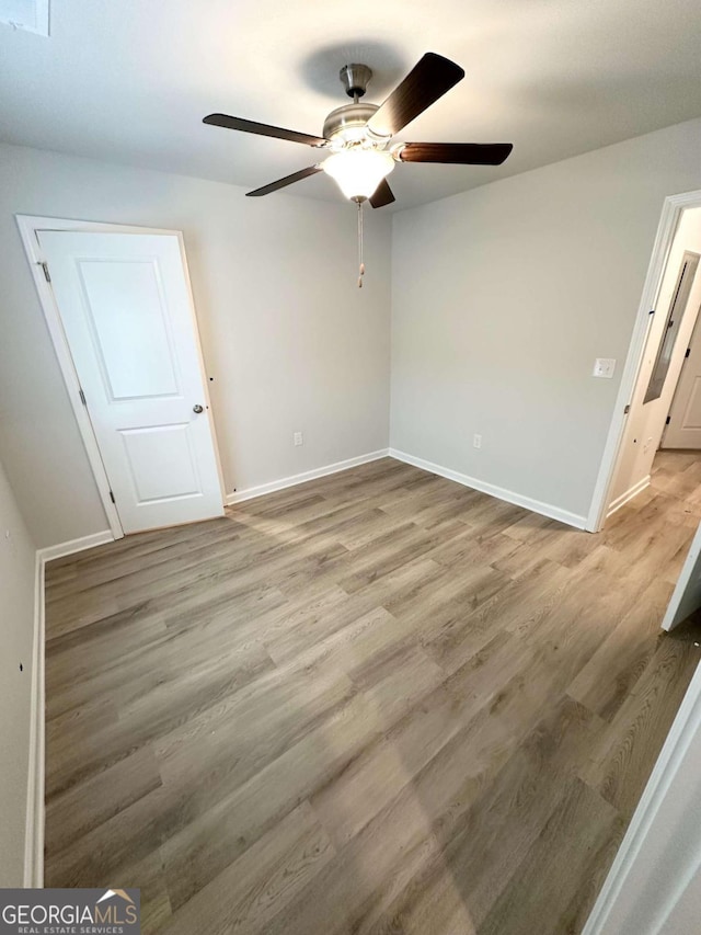 unfurnished room featuring light wood-type flooring and ceiling fan