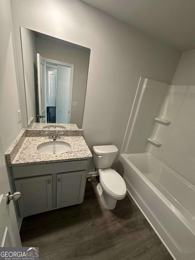 full bathroom with bathtub / shower combination, hardwood / wood-style floors, toilet, and vanity