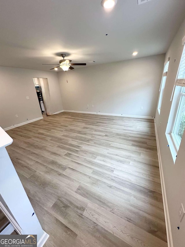 unfurnished living room with ceiling fan and light hardwood / wood-style floors