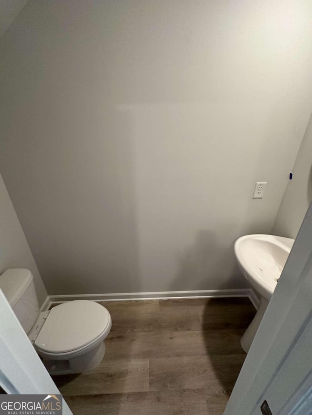 bathroom with wood-type flooring and toilet