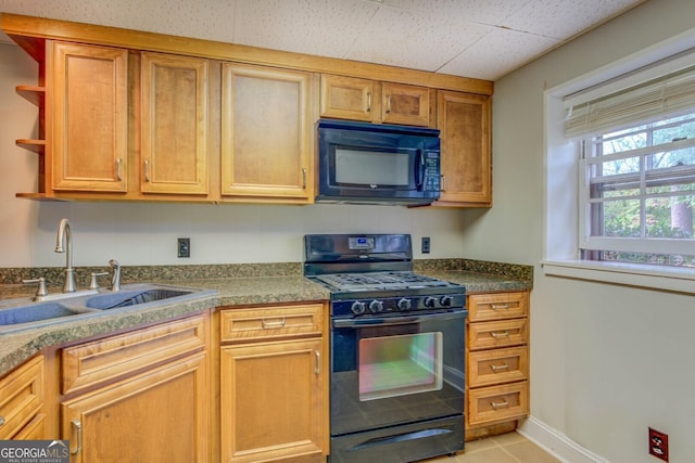 kitchen featuring sink, light tile patterned floors, and black appliances